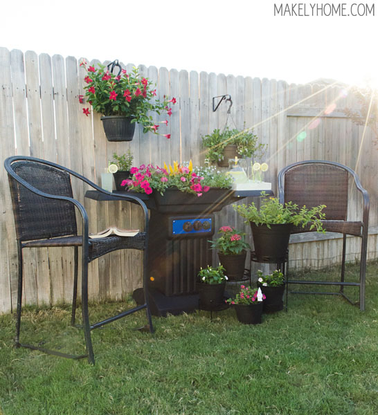 Lovely outdoor sitting area featuring a flower planter made from an upcycled BBQ grill. via MakelyHome.com