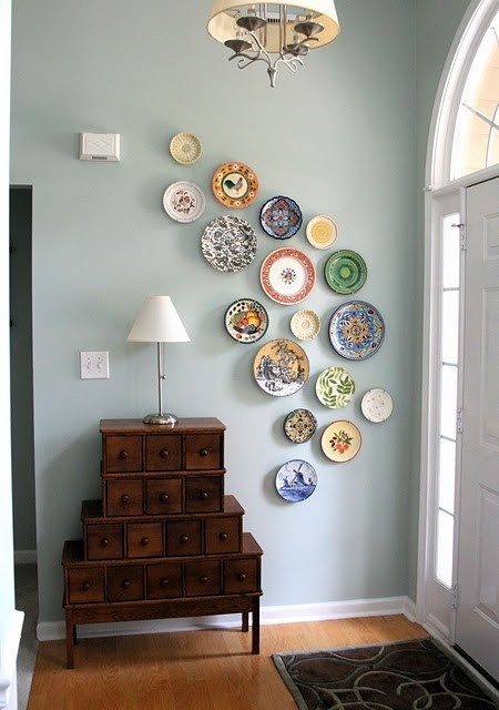 Feature wall of plates hanging in a way that gives the room some movement